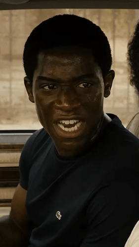 A Young Man Wearing A Black Shirt With A White Lacoste Logo GIF