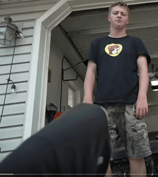 A Young Man Wearing A Black Shirt With A Yellow Bear On It GIF
