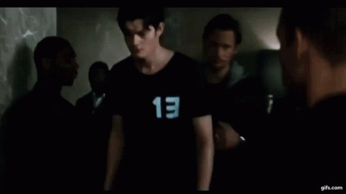 a young man wearing a black shirt with the number 13 on it .