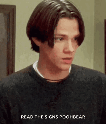 A Young Man Wearing A Black Sweater With The Words Read The Signs Poohbear Above Him GIF