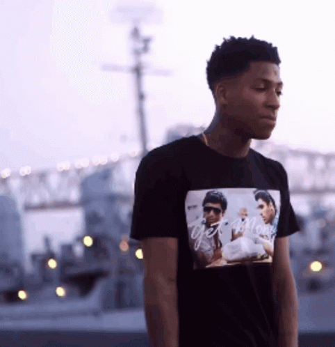 A Young Man Wearing A Black T-Shirt With A Picture Of Two Men On It GIF