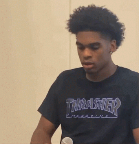 A Young Man Wearing A Black Thrasher T-Shirt Is Holding A Microphone GIF
