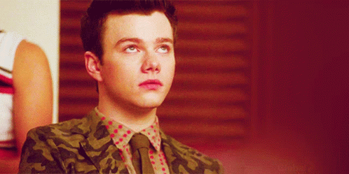 A Young Man Wearing A Camouflage Jacket And Tie GIF
