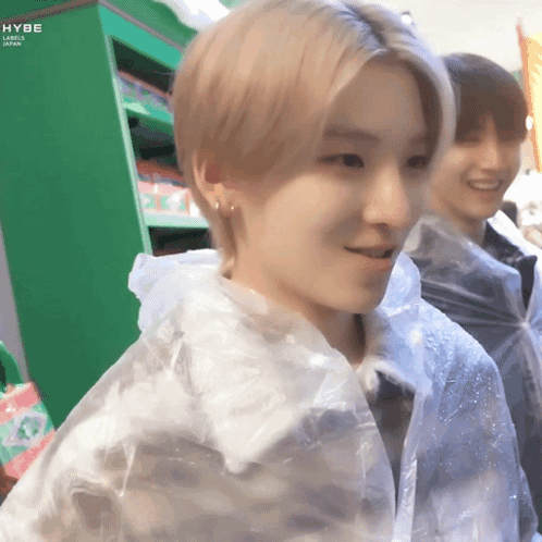 A Young Man Wearing A Clear Plastic Raincoat Is Smiling GIF
