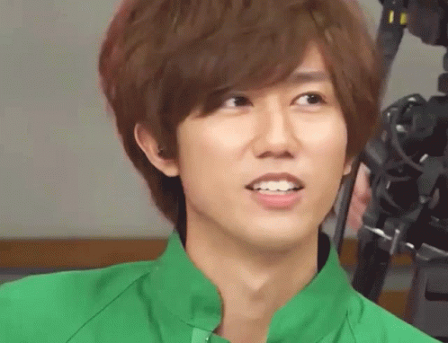 A Young Man Wearing A Green Shirt Is Smiling For The Camera GIF