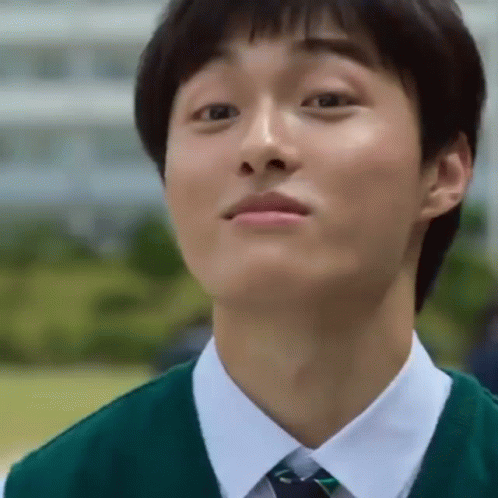 A Young Man Wearing A Green Vest And Tie Looks Up At Something GIF