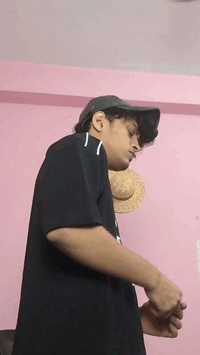 A Young Man Wearing A Hat And A Black Shirt With The Letter N On It GIF