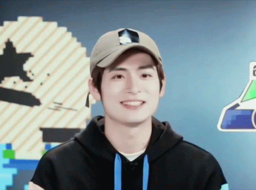 A Young Man Wearing A Hat And A Hoodie Smiles For The Camera GIF