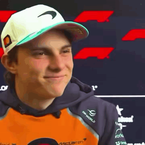 A Young Man Wearing A Hat And A Hoodie With The Word Mclaren On It . GIF