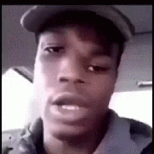 A Young Man Wearing A Hat Is Looking At The Camera . GIF