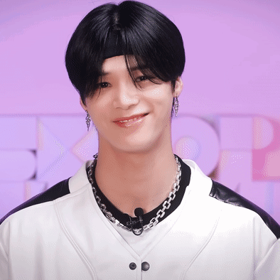 A Young Man Wearing A Headband And A Necklace Smiles GIF