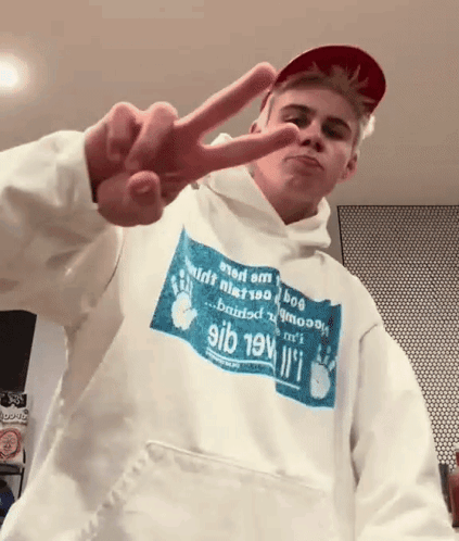 A Young Man Wearing A Hoodie That Says 9Ib 19V Giving A Peace Sign GIF