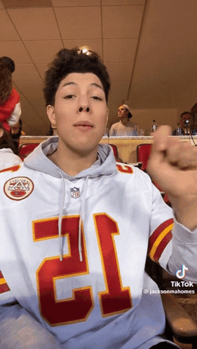 A Young Man Wearing A Hoodie With The Number 12 On It GIF
