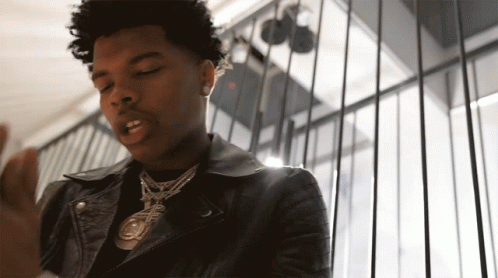 A Young Man Wearing A Leather Jacket And A Necklace With A Pendant That Says ' A ' On It GIF