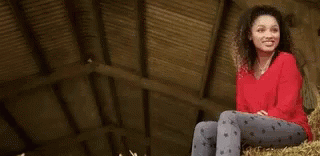 A Young Man Wearing A Plaid Shirt And A Black Shirt Is Standing In A Park . GIF