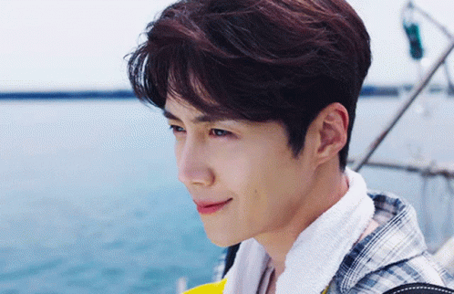 A Young Man Wearing A Plaid Shirt And A Towel Around His Neck GIF