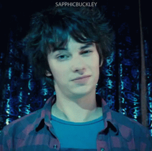 A Young Man Wearing A Plaid Shirt With The Name Sapphicbuckley On The Bottom Right GIF