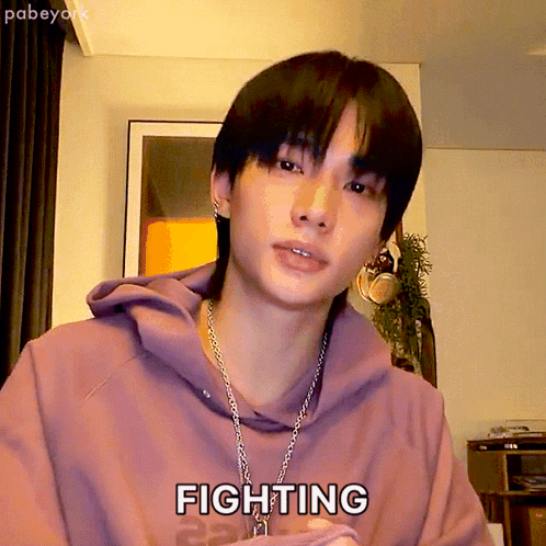 A Young Man Wearing A Purple Hoodie And A Chain Necklace Says Fighting GIF