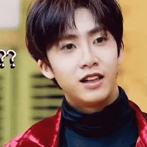 A Young Man Wearing A Red Jacket And Black Turtleneck Is Making A Funny Face . GIF
