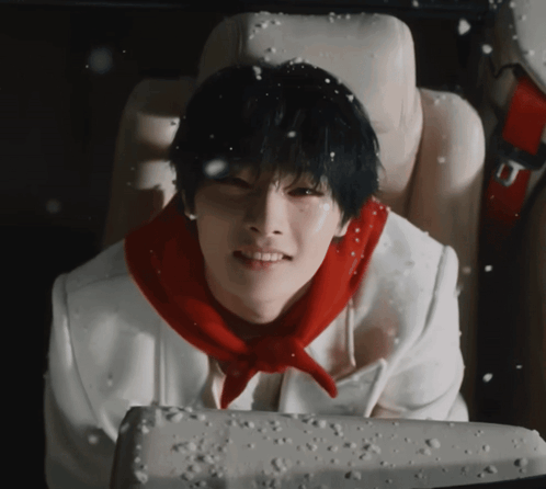 A Young Man Wearing A Red Scarf Is Sitting In A Car Seat GIF
