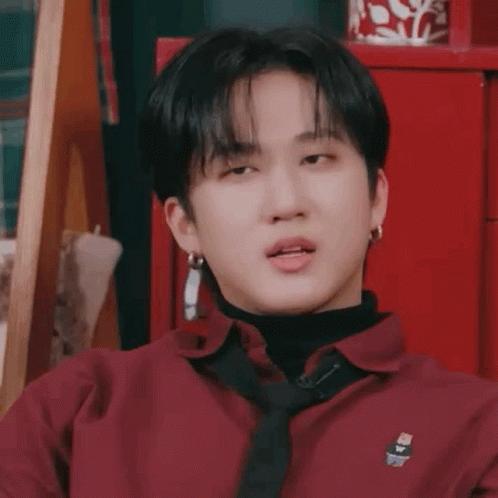A Young Man Wearing A Red Shirt And A Black Tie Is Making A Funny Face . GIF