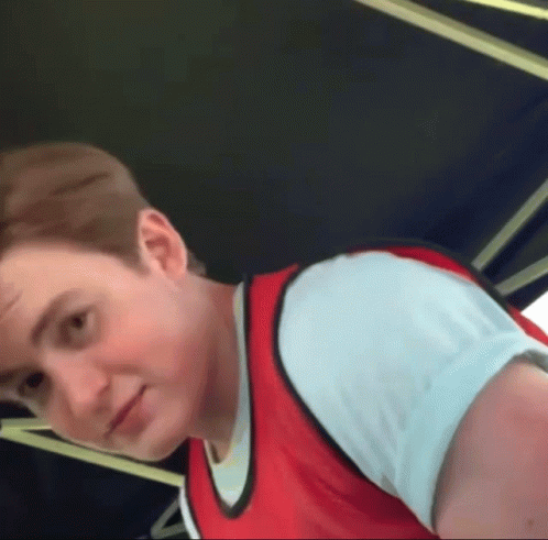 A Young Man Wearing A Red Vest And White Shirt GIF