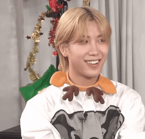 A Young Man Wearing A Reindeer Headband Smiles GIF