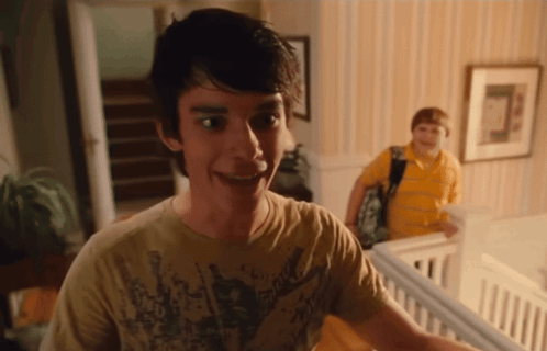 A Young Man Wearing A Shirt That Says ' Rock ' On It Smiles GIF