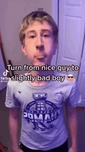 A Young Man Wearing A T-Shirt That Says `` Turn From Nice Guy To Slightly Bad Boy '' GIF