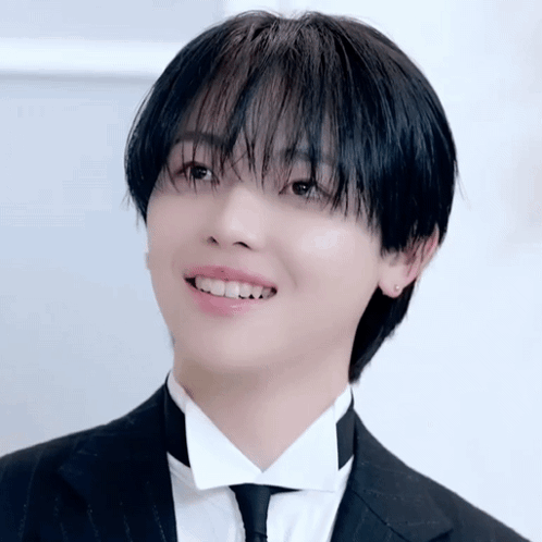 A Young Man Wearing A Tuxedo And Tie Is Smiling GIF