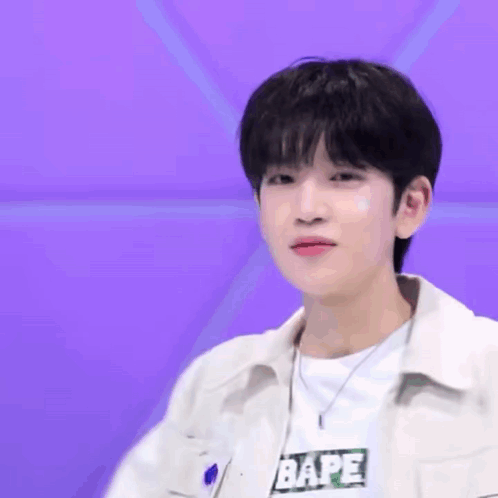 A Young Man Wearing A White Jacket And A White Shirt With The Word Bape On It GIF