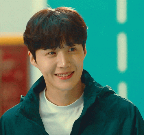A Young Man Wearing A White Shirt And A Green Jacket Smiles For The Camera GIF