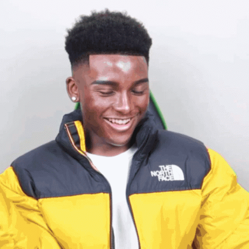A Young Man Wearing A Yellow North Face Jacket Smiles GIF