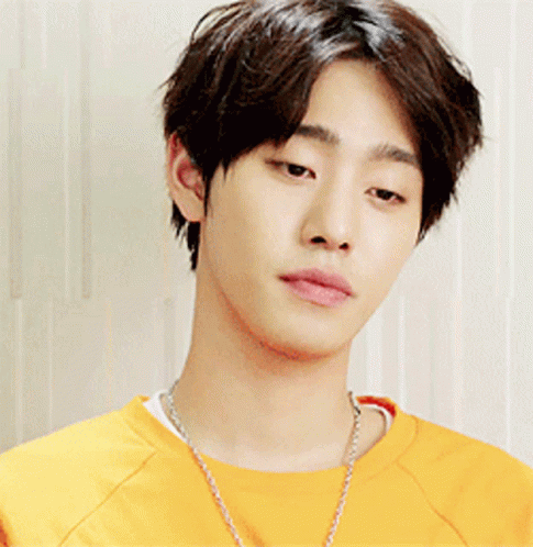 A Young Man Wearing A Yellow Shirt And A Necklace GIF