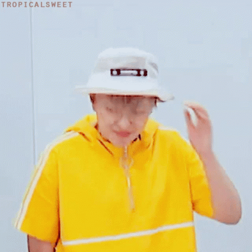 A Young Man Wearing A Yellow Shirt And A White Hat . GIF