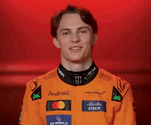 A Young Man Wearing An Orange Jacket With Logos For Android And Cisco On It GIF