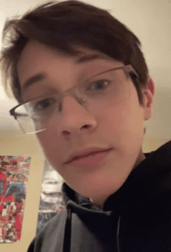 A Young Man Wearing Glasses And A Black Hoodie GIF