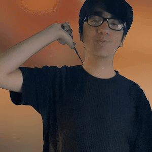 A Young Man Wearing Glasses And A Black Shirt Is Holding A Knife GIF
