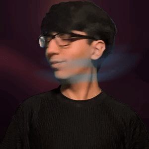 A Young Man Wearing Glasses And A Black Shirt Looks At The Camera GIF
