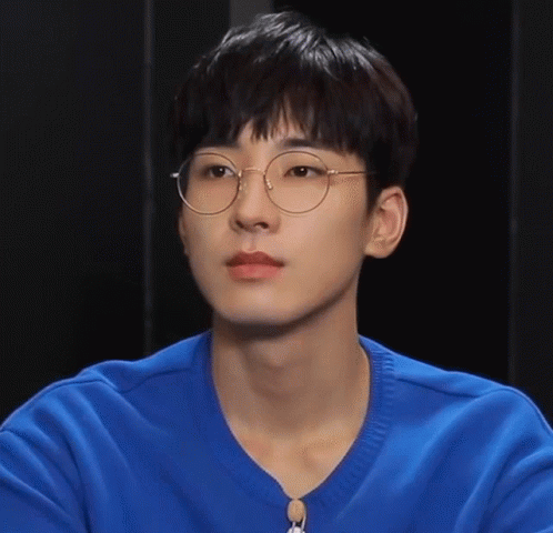 A Young Man Wearing Glasses And A Blue Shirt Looks At The Camera GIF