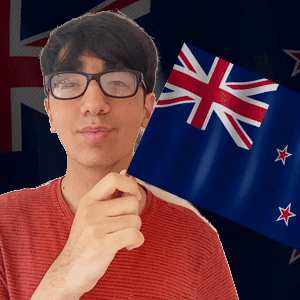 A Young Man Wearing Glasses Holds A Small Flag In Front Of A British Flag GIF