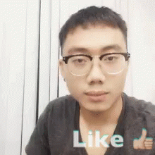 A Young Man Wearing Glasses Is Giving A Thumbs Up Sign . GIF