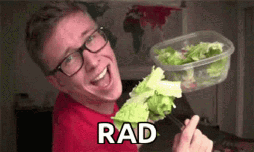 A Young Man Wearing Glasses Is Holding A Container Of Lettuce And A Fork . GIF