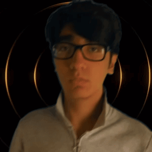 A Young Man Wearing Glasses Looks At The Camera GIF