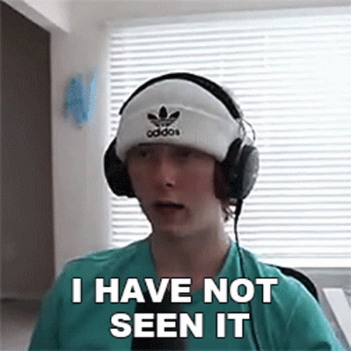 A Young Man Wearing Headphones And A Beanie Is Making A Funny Face . GIF