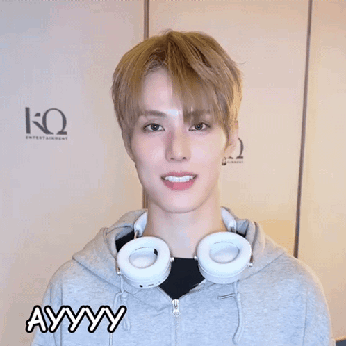 A Young Man Wearing Headphones And A Grey Hoodie Is Making A Funny Face And The Word Ayyy Is Above Him GIF