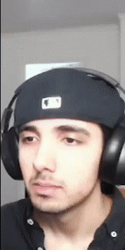 A Young Man Wearing Headphones And A Hat . GIF