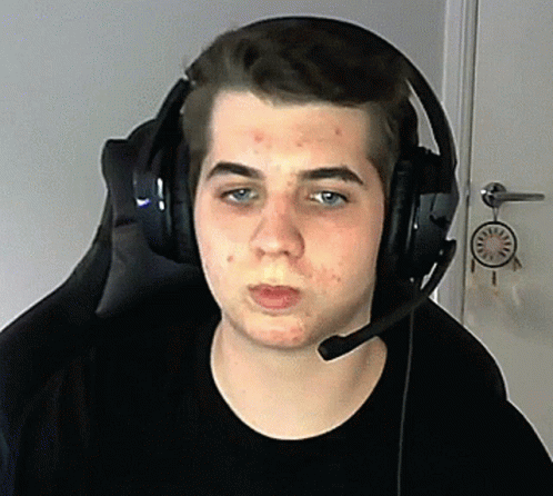 A Young Man Wearing Headphones And A Microphone Is Sitting In A Chair GIF