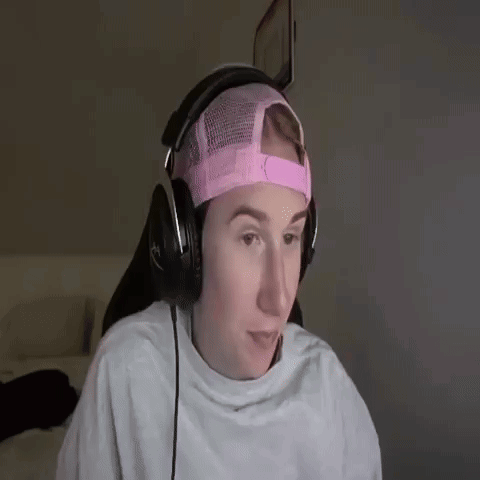 a young man wearing headphones and a pink hat .