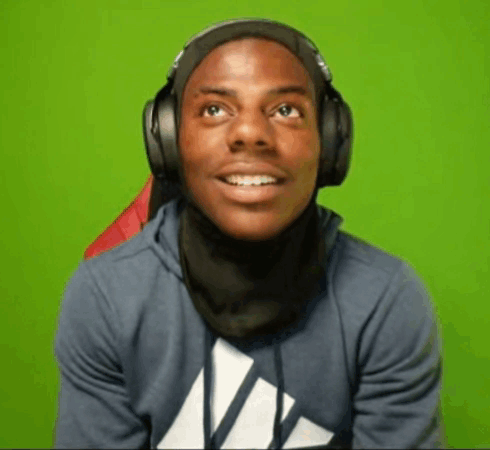 A Young Man Wearing Headphones And A Scarf Around His Neck Is Smiling . GIF